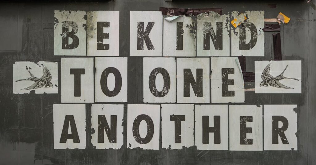 Close-up of 'Be Kind to One Another' message on a weathered background.